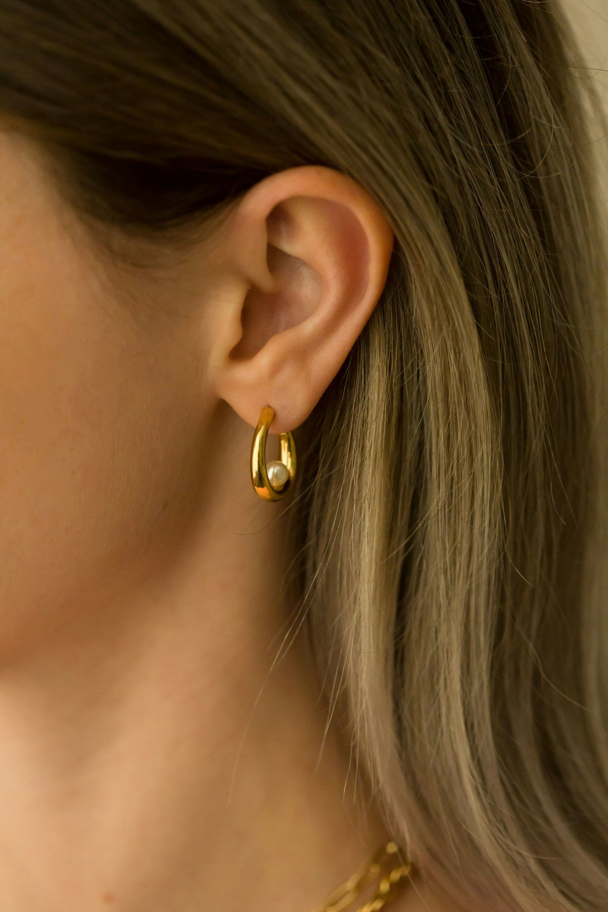 Placeholder photograph, replace before launch: a gold hoop worn at the ear