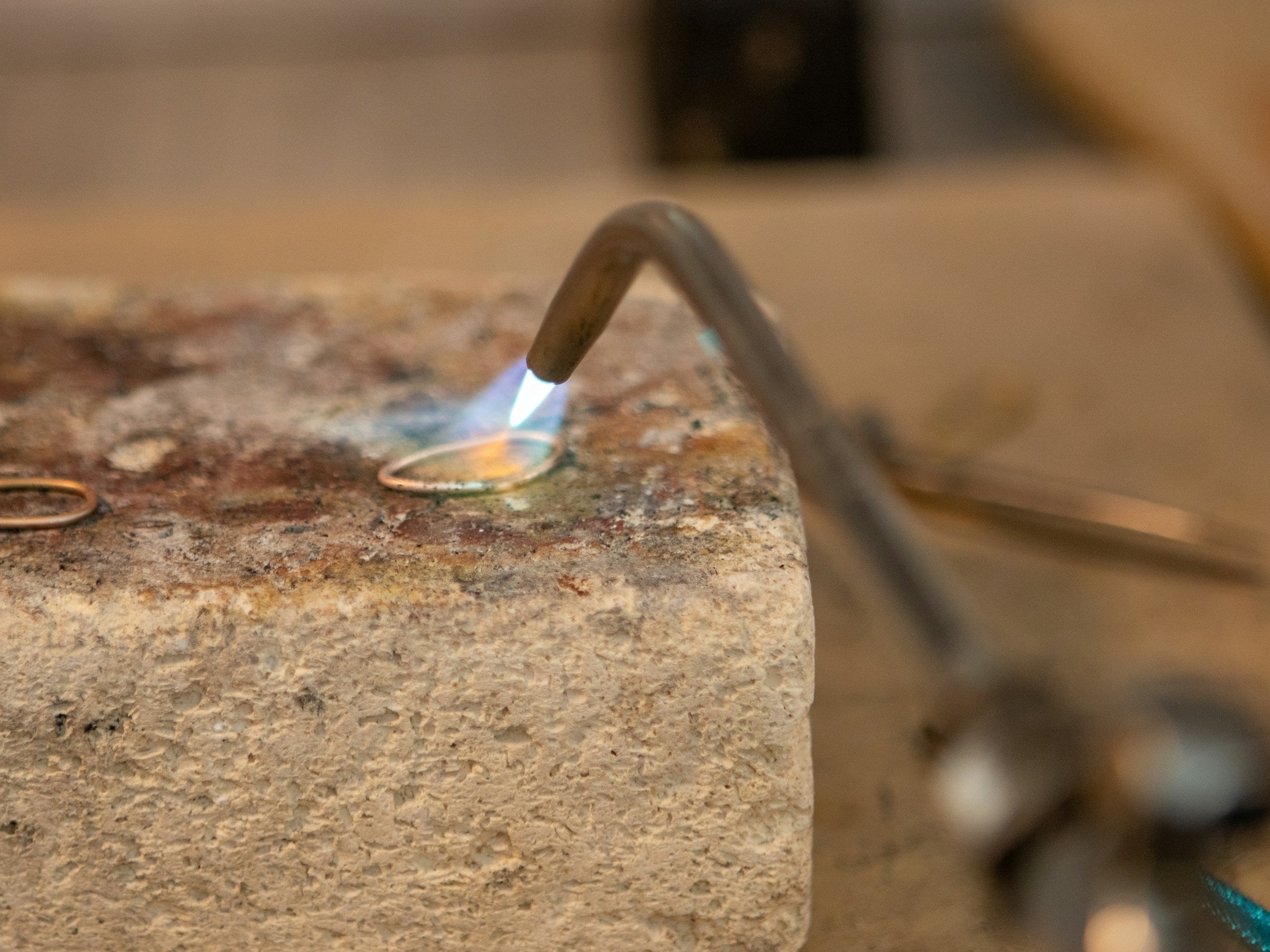 Placeholder photograph, replace before launch: a ring being soldered at the bench